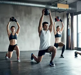 People exercising with kettle balls in group class