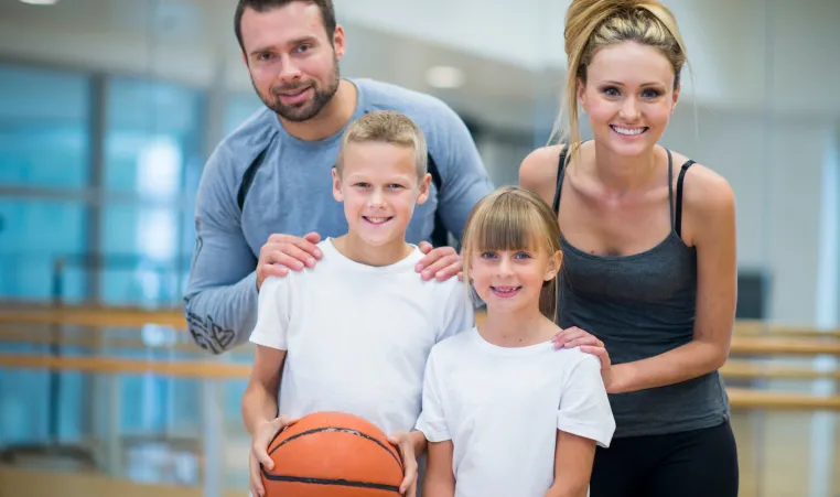 Parents and kids at gym holding basketball