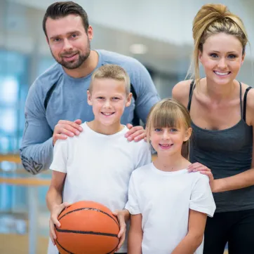 Parents and kids at gym holding basketball